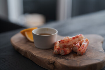 Crab served with sauce and sweet lemon on olive wood board
