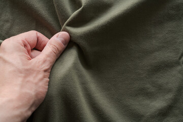 top view man hand touching green cotton fabric