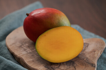ripe fresh mango on olive wood board closeup