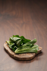 Small romaine lettuce leaves on wood board