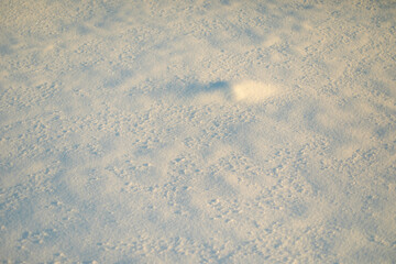 Texture of snow in sunlight. Snow lies outside. Cold weather.