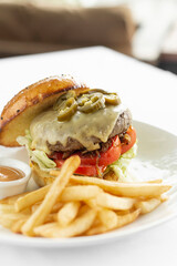 jalapeno cheese burger with french fries on restaurant table