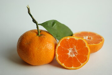 ripe and juicy tangerine (mandarin). fresh tangerine with leaf on white, closeup
