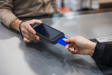 Woman at the time of credit cart payment at the payment terminal