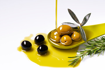 in the foreground a drizzle of extra virgin olive oil is poured into a green ladle with rosemary-flavored olives - obrazy, fototapety, plakaty