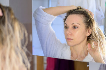 Woman with open hair looking at mirror.