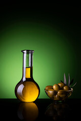 in the foreground a glass cruet with Italian extra virgin olive oil. Side bowl with olives. still life
