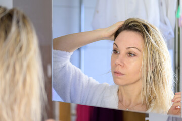 Fototapeta premium Woman with open hair looking at mirror.