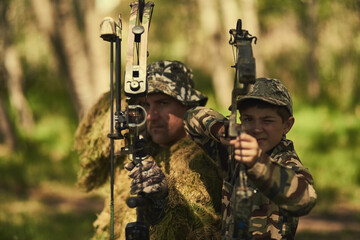 Theyre a deadly duo. Portrait of a father and son in camouflage hunting with bows and arrows in the...