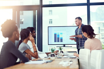 Delving into the numbers. Cropped shot of a young man giving a presentation to his team.