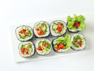 vegetable vegetarian sushi roll with vegetables in nori on a white plate isolated