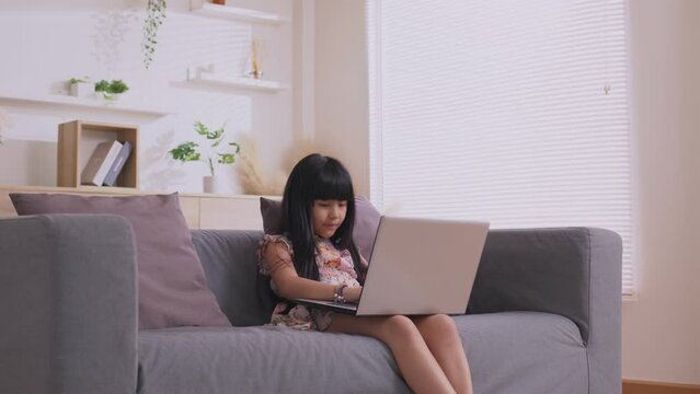 Asian girl using computer laptop playing game and social media or chatting with her friends.