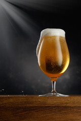 Glass of light beer on dark background. Selective focus