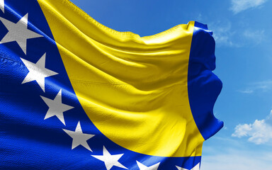 Bosnia and Herzegovina Flag is Waving Against Blue Sky with Clouds