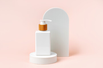 Pump bottle mockup on podium with  arch on  beige  background. Natural skincare beauty product.  Branding and packaging presentation.