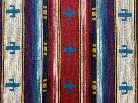 Folk ornament on a blanket. Ethnic tapestry ornament. Close-up colorful rug or carpet. Carpeting texture. Folk ornament.