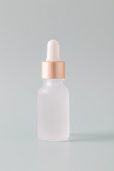 Frosted glass bottle with dropper pipette with serum or essential oil on a blue background. Skincare cosmetic Beauty concept for face body care. Place for text
