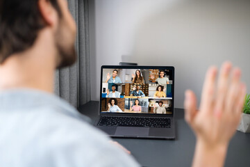 Caucasian freelancer man waving hello into laptop webcam, guy connected via video with family, friends or colleagues working remotely from home. Video call concept