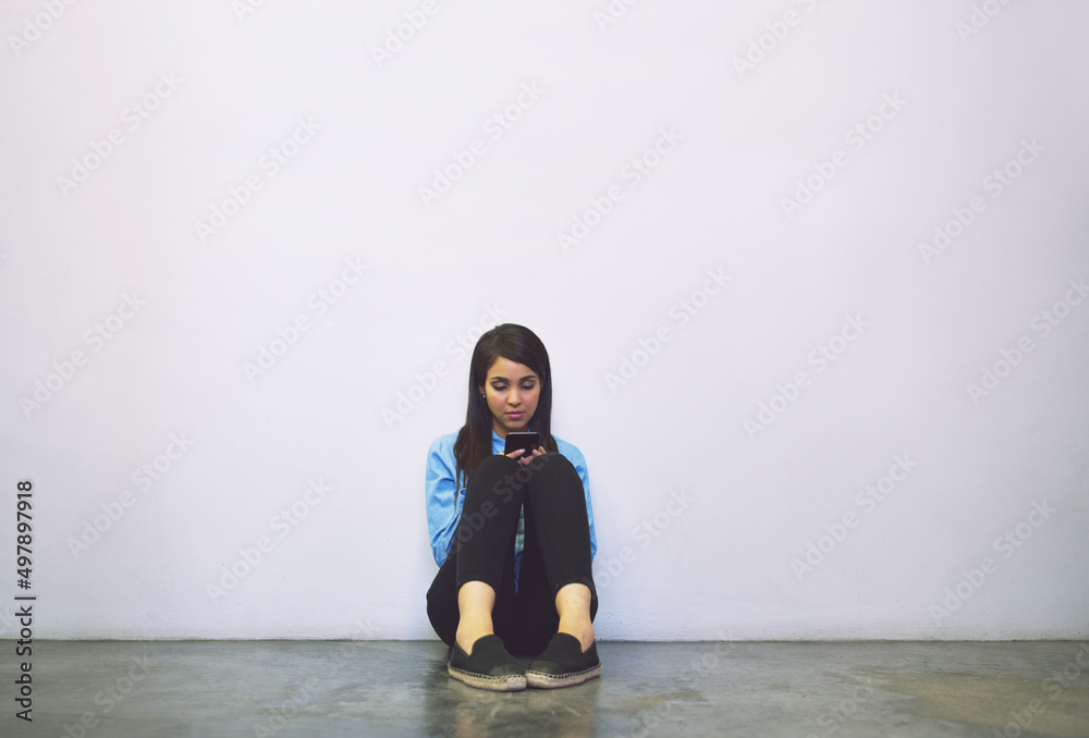 Aufkleber shes between classes. shot of an attractive young college student using her cellphone while sitting 
