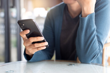 using cell phone hand holding mobile texting message contact us.chatting,search internet information in office.technology device communication connecting