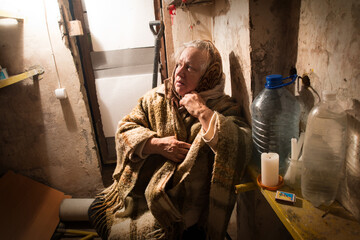 Frightened woman hide from explosions in the basement. During the sirens due to the shelling of Kyiv. Ukraine. 26 February 2022