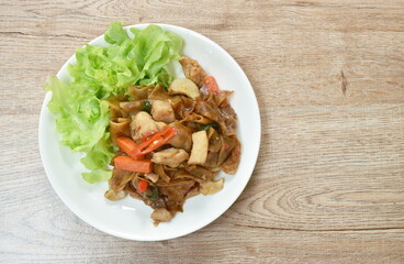 spicy fried large rice noodles with chicken and slice mushroom on plate