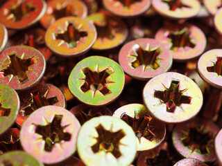 Anodized screw caps close-up. A vivid illustration on the theme of hardware and fasteners. Materials for construction and repair. Self drilling screws. Macro