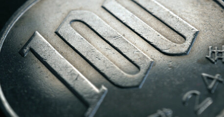Japanese 100 yen coin closeup. Horizontal stories for news about the economy and banking in Japan. Scratched textured money from circulation. Dark hundred yen. Macro