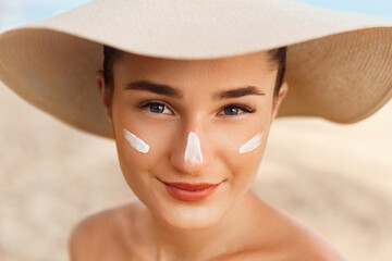 Beautiful Woman smile applying sun cream on face. Skin and  Body  care. Sun protection. Girl in...