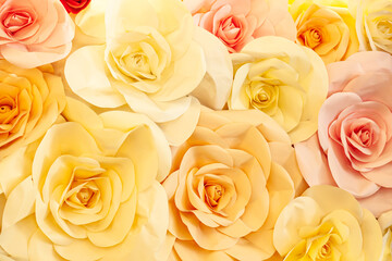 Artificial flowers of yellow and pink roses close-up.