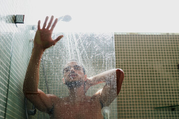 Naklejka na ściany i meble The shower is a great place to cool off. Cropped shot of a handsome young man having a refreshing shower at home.