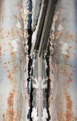 close up of rusty metal and it's reflection in a window