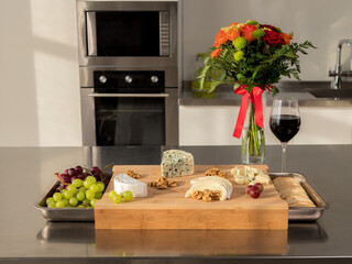 Delicious variety appetizers for wine cheese grapes on the wooden plate in the kitchen