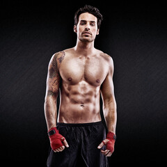 Portrait of pure fighting prowess. Studio shot of a confident young boxer isolated on black.