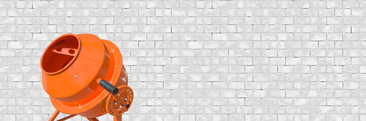 Panoramic banner of Orange concrete mixer at building construction works on white brick wall...