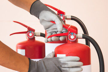 Close up fire extinguisher and firefighter squeeze to check the handle for protection and prevent and safety rescue and use of equipment on fire training concept.