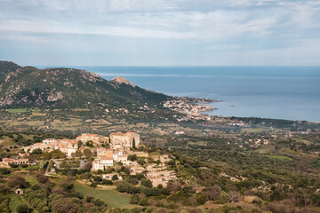 Obraz premium Hilltop village of Pigna in the Balagne region of Corsica with Mediterranean sea in the distance