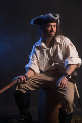 Pirate filibuster sea robber in suit with gun and saber. Concept photo