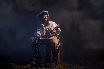 Fototapeta na wymiar Pirate filibuster sea robber in suit with gun and saber. Concept photo