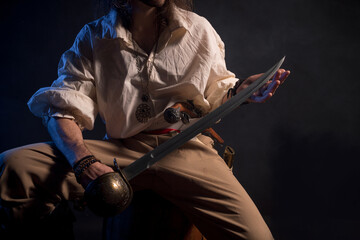 Fototapeta na wymiar Pirate filibuster sea robber in suit with gun and saber. Concept photo