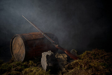 Ancient musket on a barrel among the smoke on the battlefield
