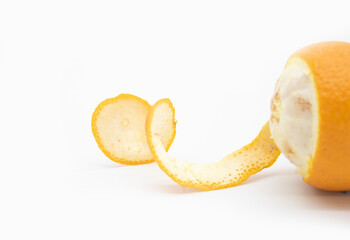 Orange skin slice with colorful sprinkle close up on white background, selective focus