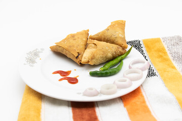 Samosa in a plate with onion isolated on white background,
