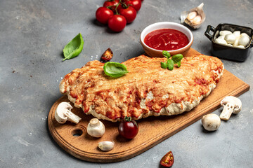 Homemade calzone vegetarian pizza with mushrooms, tomatoes, mozzarella cheese and fresh basil, italian calzone vegetarian pizza, top view,