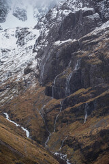 Fototapeta na wymiar Majestic Winter landscape image of snowcapped Three Sisters mountain range in Glencoe Scottish Highands with dramatic sky