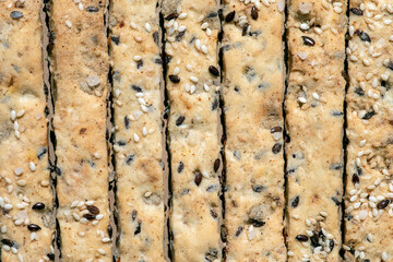 Background of bread sticks with flax and sesame seeds.