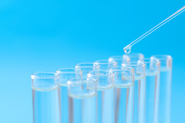 Liquid drop to test tube on blue background