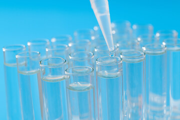 Liquid drop to test tube on blue background