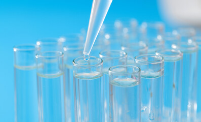 Liquid drop to test tube on blue background