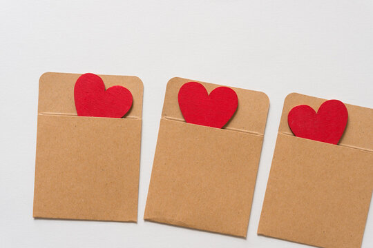 painted wooden hearts in plain brown pocket envelopes